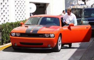 Arnold Schwarzenegger with Dodge Challenger SRT image.