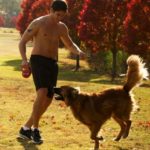 Steven R McQueen playing with his pet dog