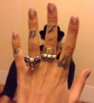 Lou Teasdale Tattoo on left hand fingers